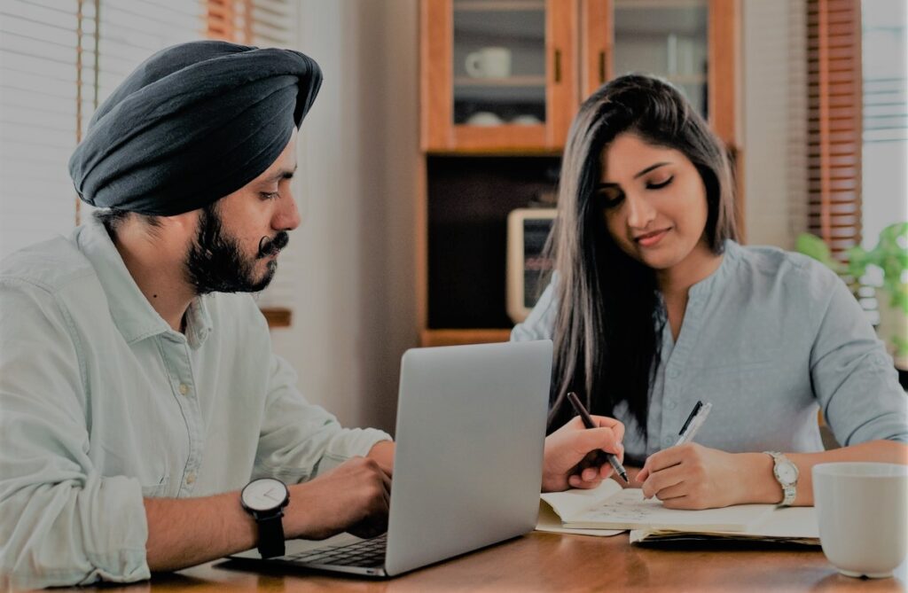 Two people sitting by a computer